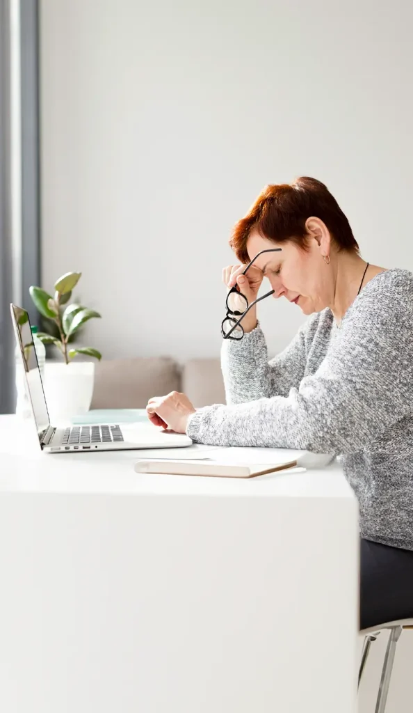 CEAPSI. Estres. Adulto sentado en comedor, pensativo, representando estres laboral.
